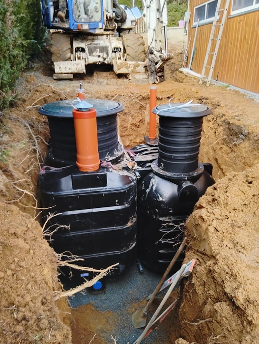 Chantier extérieur de terrassement, installation de deux cuves enterrées en polyéthylène haute densité (PEHD) noir