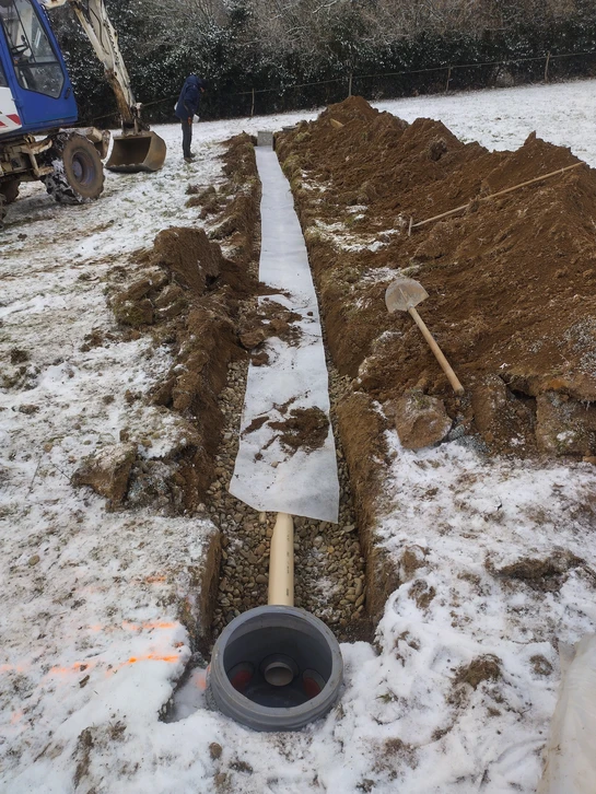 Chantier extérieur en milieu naturel sur terrain en pente, vue panoramique sur vallée verdoyante