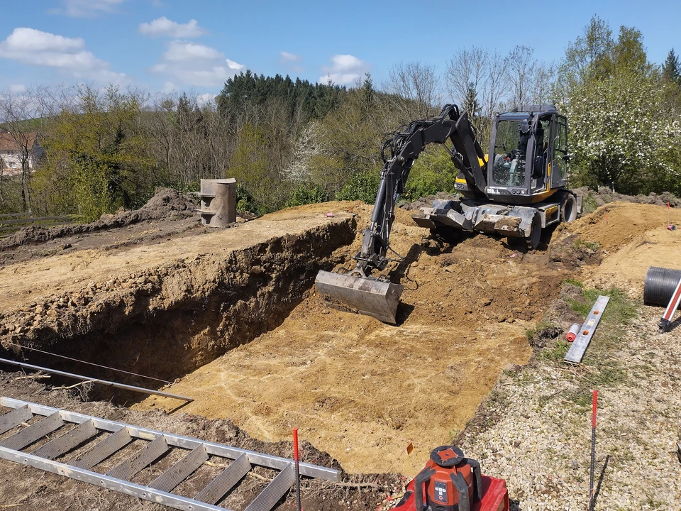 Chantier de terrassement en extérieur avec pelleteuse hydraulique déchargeant de la terre dans une benne de camion