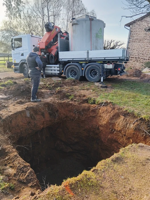 Pose d'une cuve de stockage cylindrique en béton par camion-grue avec flèche articulée et élingues à chaînes