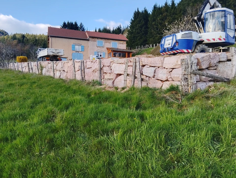 Chantier de terrassement en extérieur avec pelleteuse hydraulique rouge sur chenilles en action