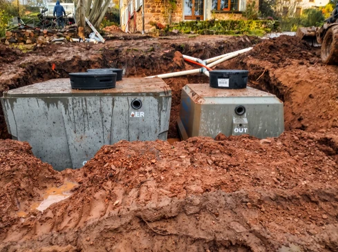 Chantier extérieur de terrassement, installation de deux cuves enterrées en polyéthylène haute densité (PEHD) noir
